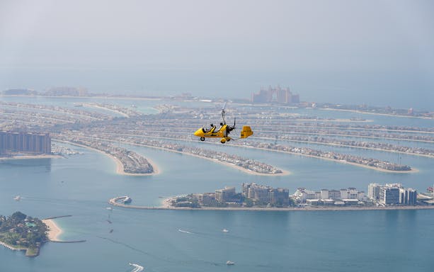 Gyrocopter flying over Palm Jumeirah in Dubai.