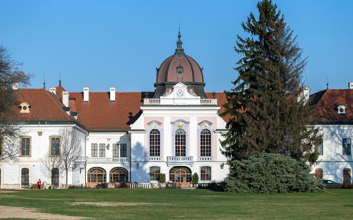 Royal Palace of Godollo facade with clock tower and gardens in Hungary.