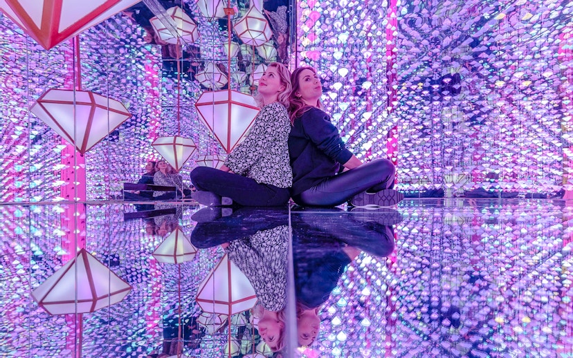 Visitors in mirrored room with colorful lights at Studio Irma, Moco Amsterdam.