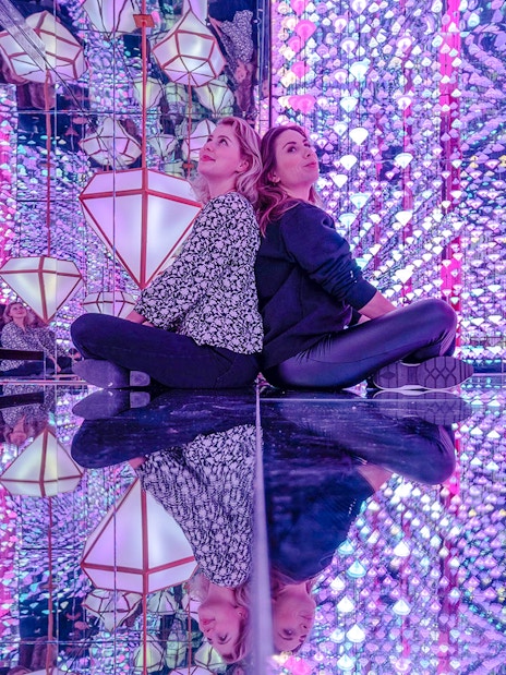Visitors in mirrored room with colorful lights at Studio Irma, Moco Amsterdam.
