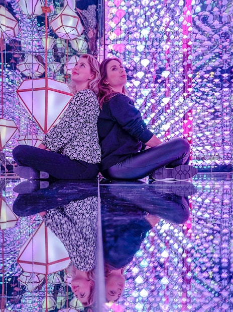 Visitors in mirrored room with colorful lights at Studio Irma, Moco Amsterdam.