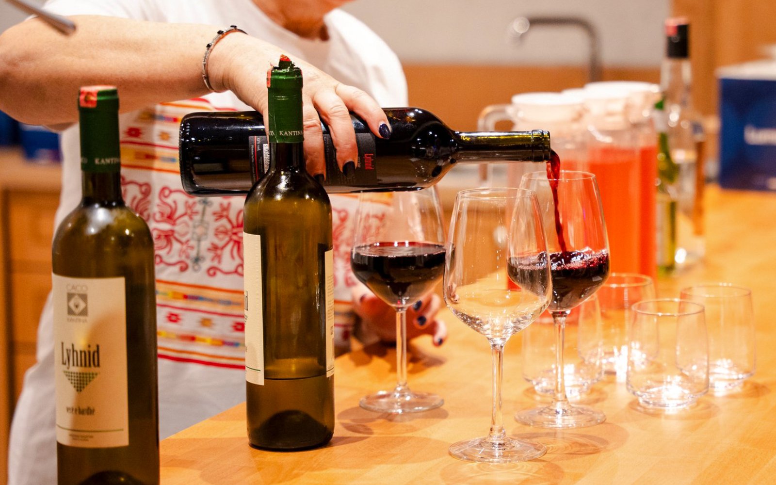 Pouring red wine into glasses during Albanian Night Cultural Dance & Music Experience.