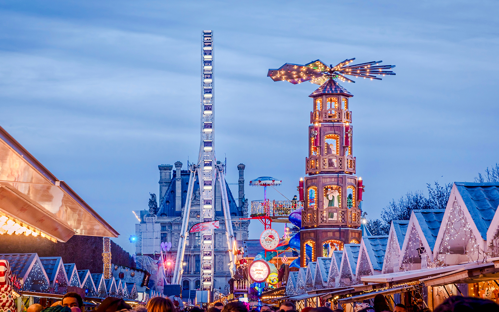 Christmas Market at Tuileries Garden in Paris with festive stalls and Ferris wheel.