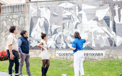 Visitors observing the Guernica mural in San Sebastian, Spain.