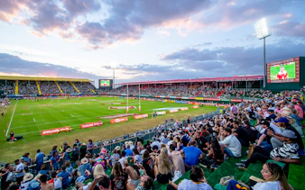 Crowd watching rugby match at Emirates Dubai 7s stadium.