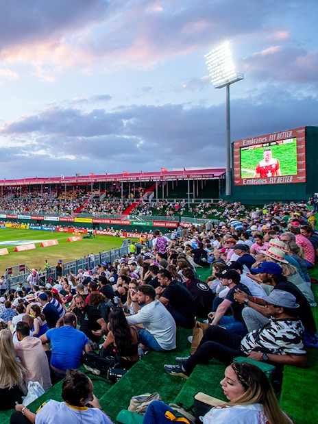 Crowd watching rugby match at Emirates Dubai 7s stadium.