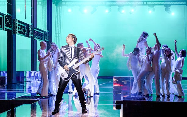 Performer with guitar on stage during Rock Me Amadeus musical in Vienna.