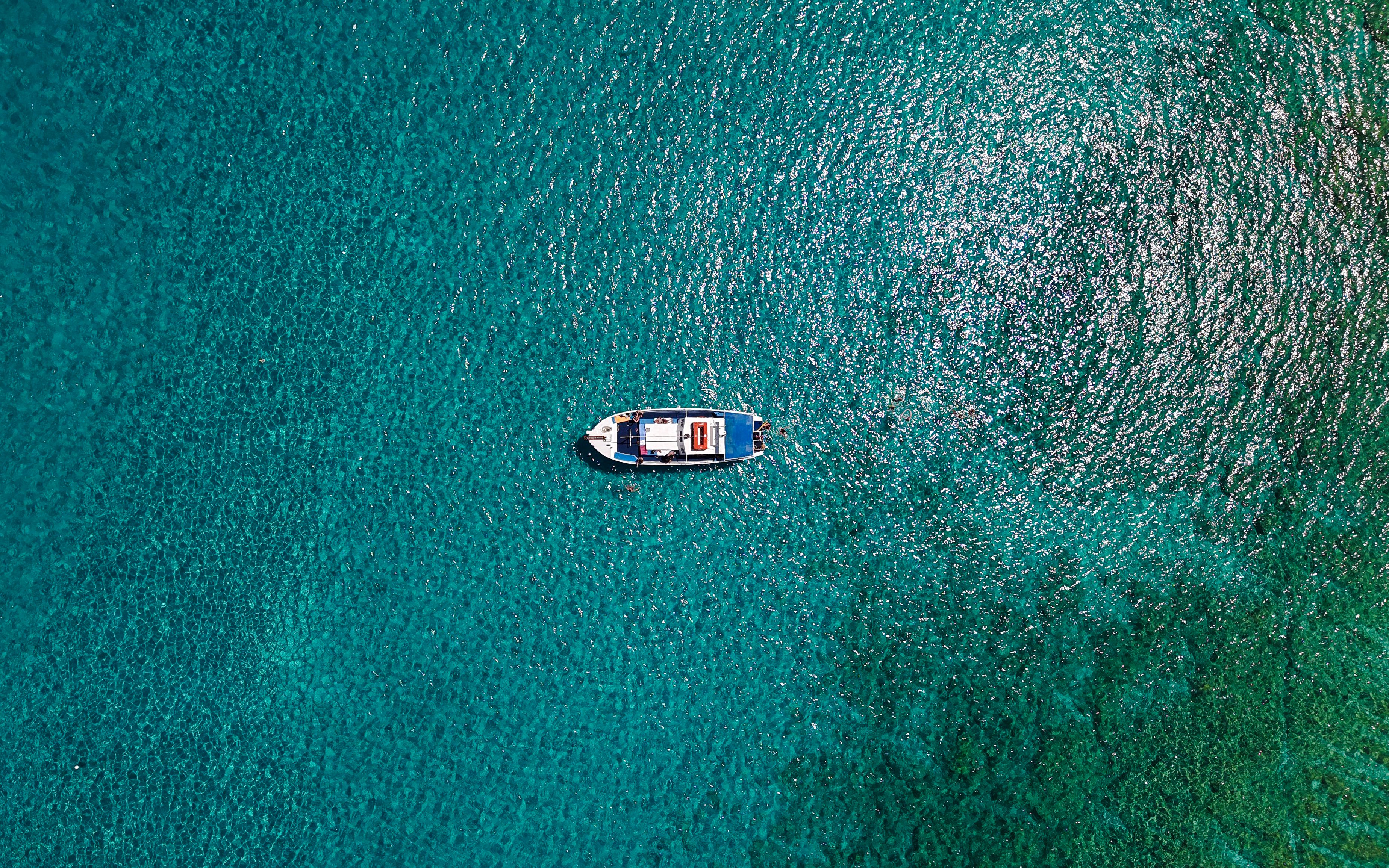 Boat cruising on turquoise sea during Lindos tour.