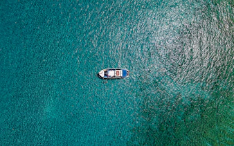 Boat cruising on turquoise sea during Lindos tour.