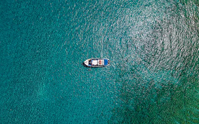 Boat cruising on turquoise sea during Lindos tour.