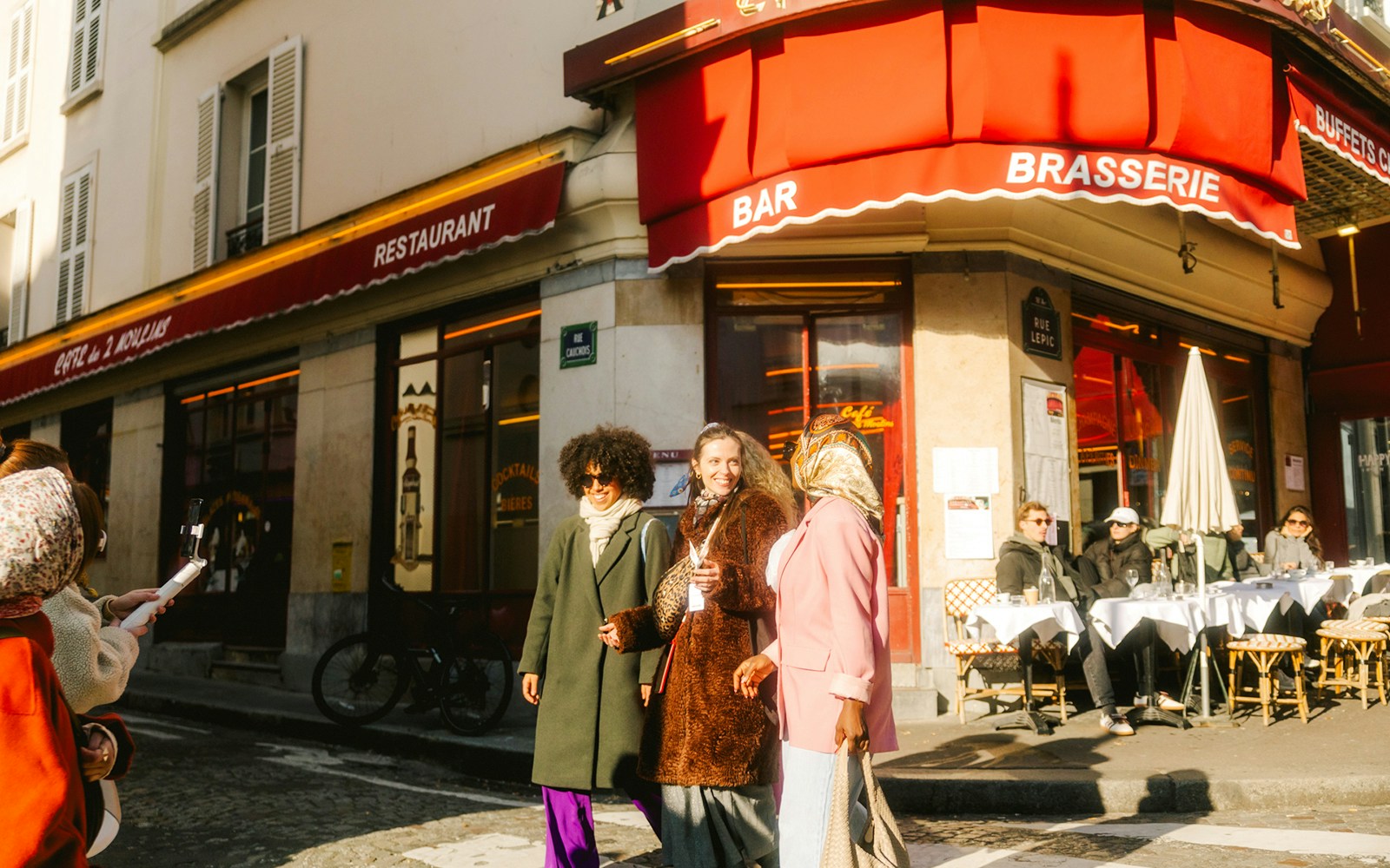 Ladies walking past a famous cafe on Rue Lepic during Emily in Paris Montmartre Walking Tour.