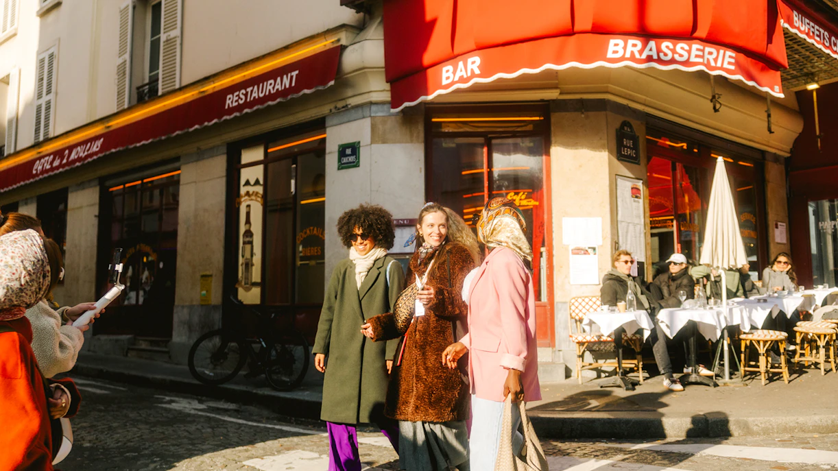 Ladies walking past a famous cafe on Rue Lepic during Emily in Paris Montmartre Walking Tour.