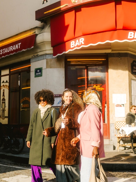 Ladies walking past a famous cafe on Rue Lepic during Emily in Paris Montmartre Walking Tour.