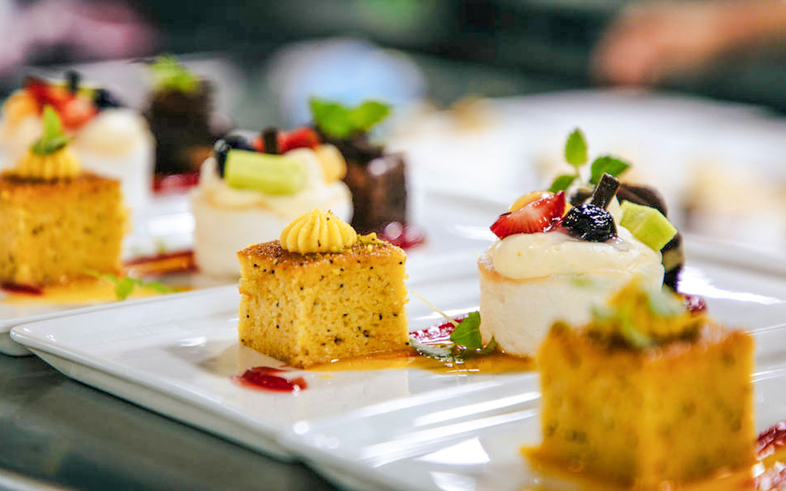 Mini cakes with fruit toppings on a buffet plate, served on a Sydney cruise.