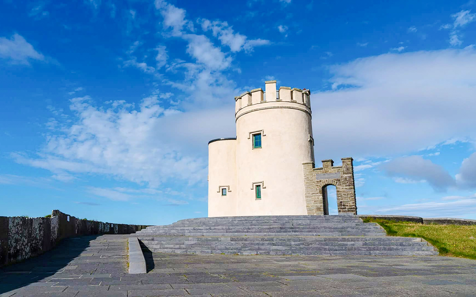 O'Brien's Tower at the Cliffs of Moher, Ireland, under a blue sky.