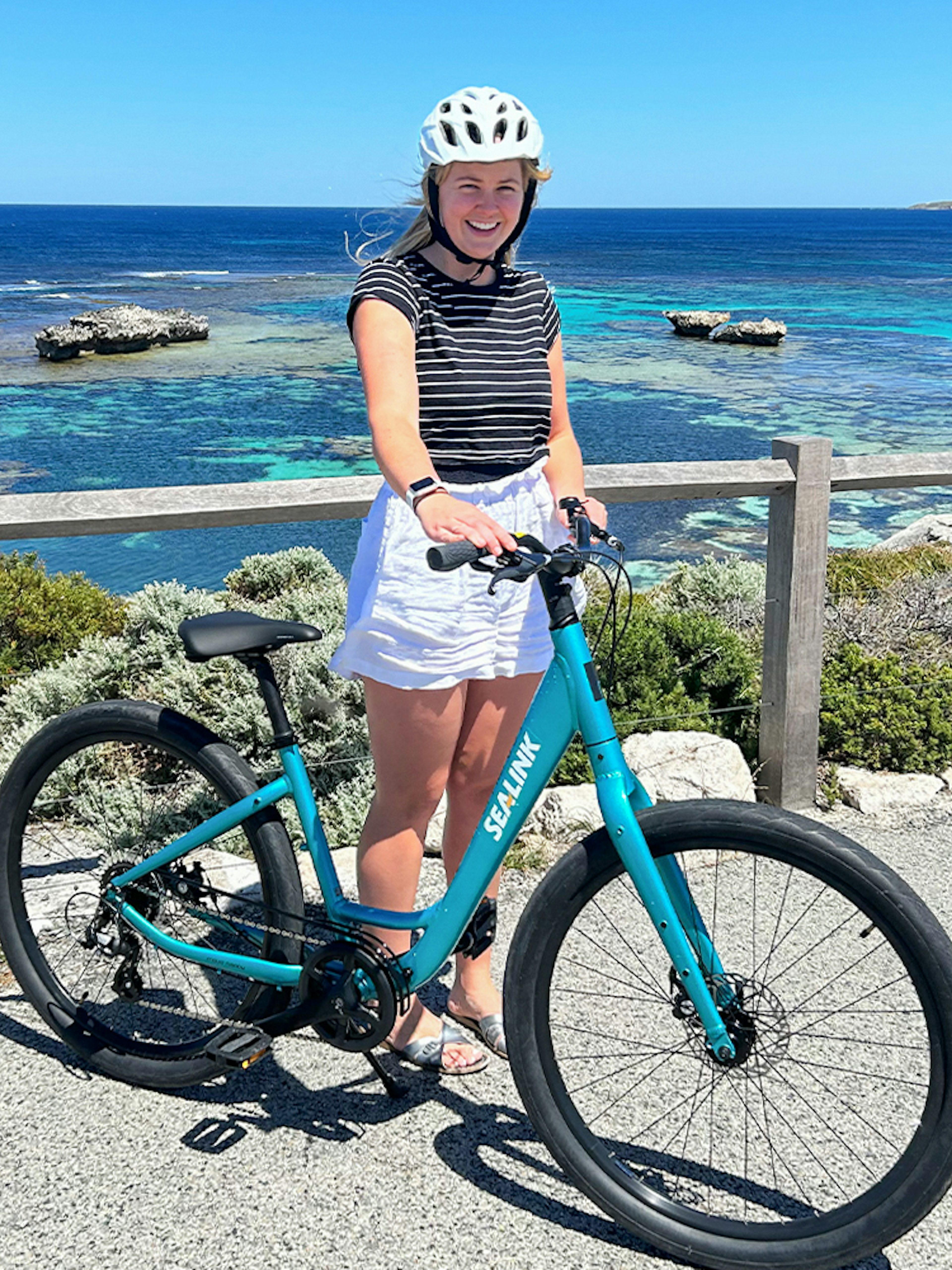 Person with a bike on Rottnest Island overlooking the ocean during a guided bus tour.