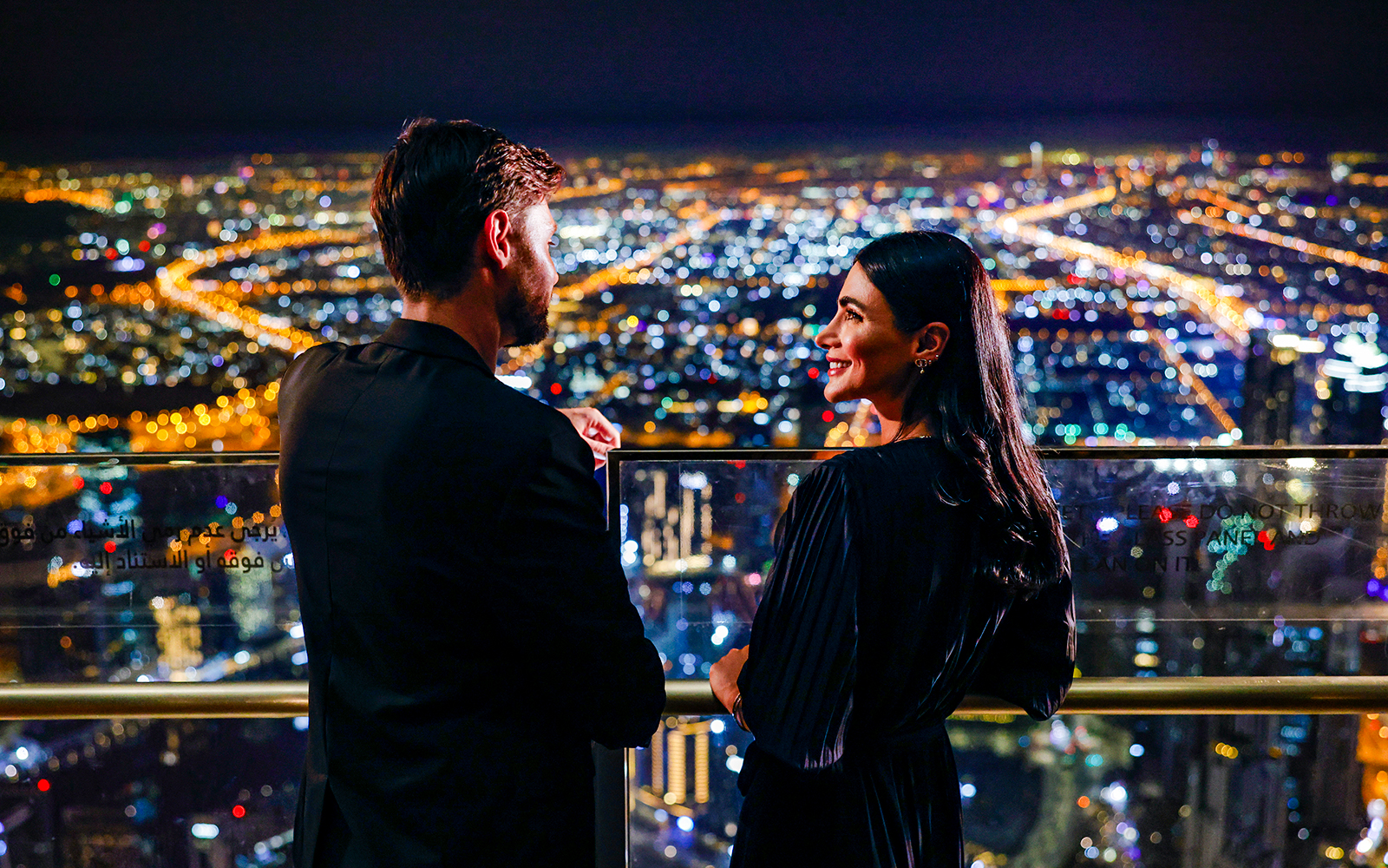 Couple enjoying night view from Burj Khalifa Level 152 Lounge, Dubai.