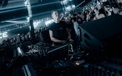 DJ performing at a packed nightclub in Ibiza with an enthusiastic crowd.