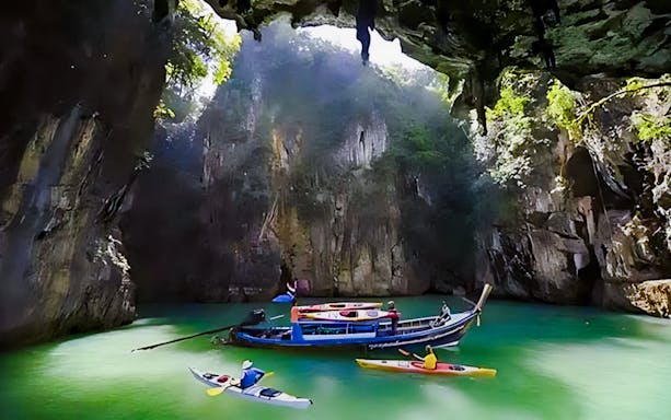 Sea canoe exploring limestone cliffs and caves at James Bond Island, Phuket.