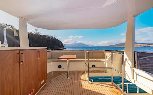Cruise deck with seating and ocean view on Hobart Half-Day Fishing, Diving & Gourmet Cruise.