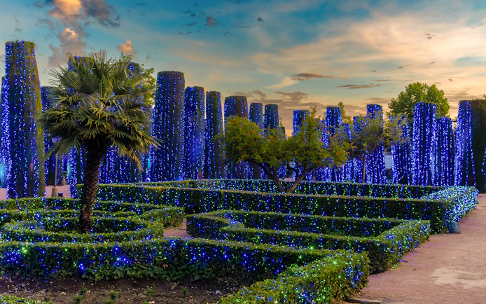 Alcazar of Cordoba garden illuminated with blue lights at night.