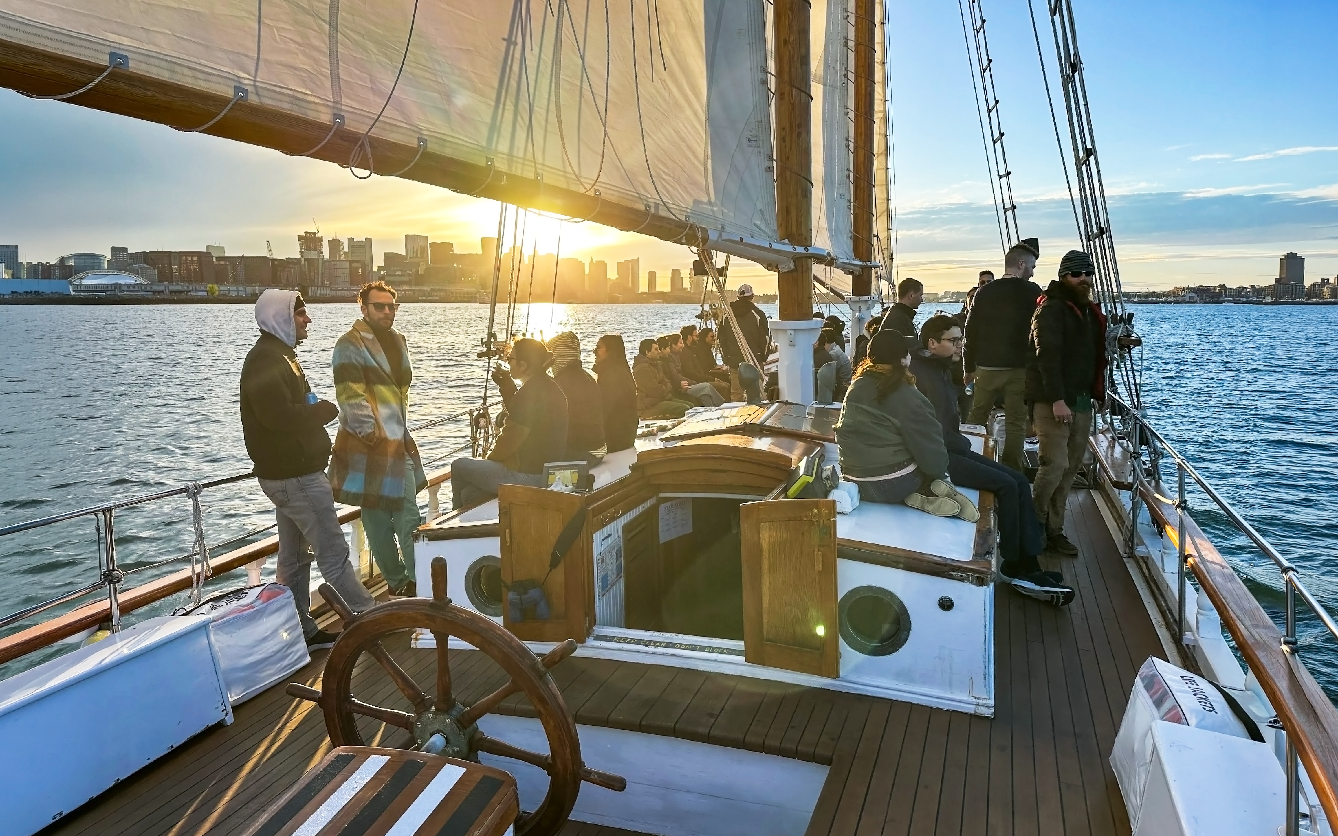People enjoying a sunset cruise on the Liberty Star with city skyline in the background.