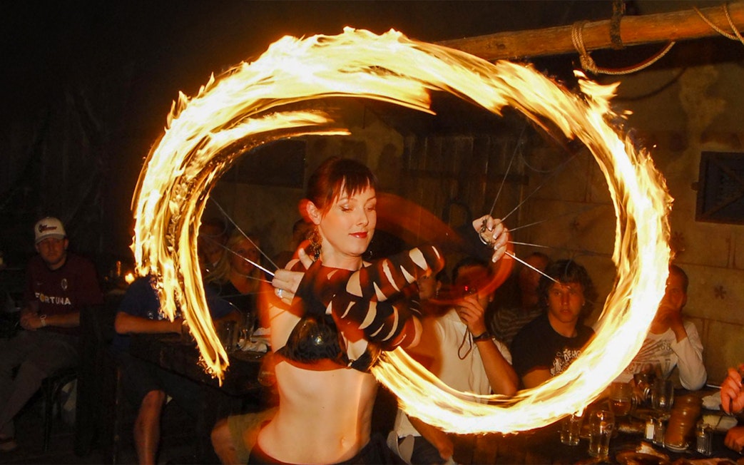 Fire performer at a medieval dinner show captivating audience with fiery display.