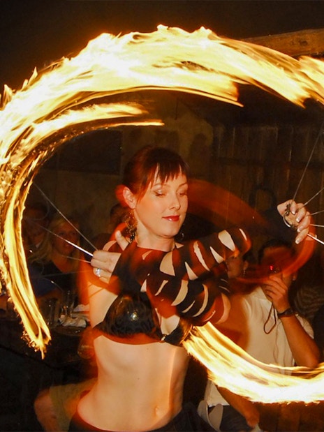 Fire performer at a medieval dinner show captivating audience with fiery display.