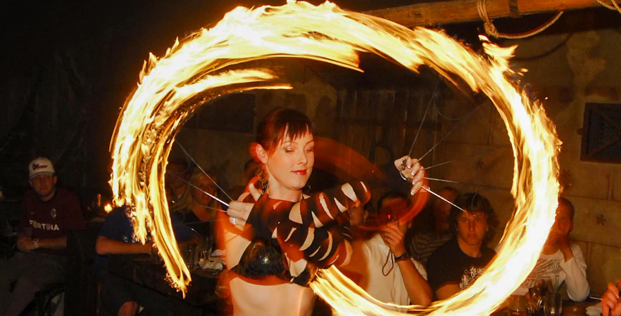 Fire performer at a medieval dinner show captivating audience with fiery display.