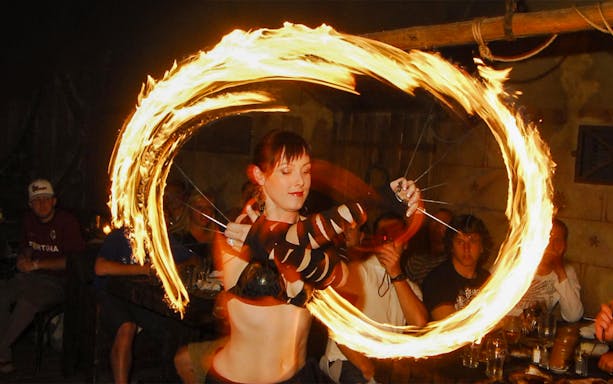 Fire performer at a medieval dinner show captivating audience with fiery display.