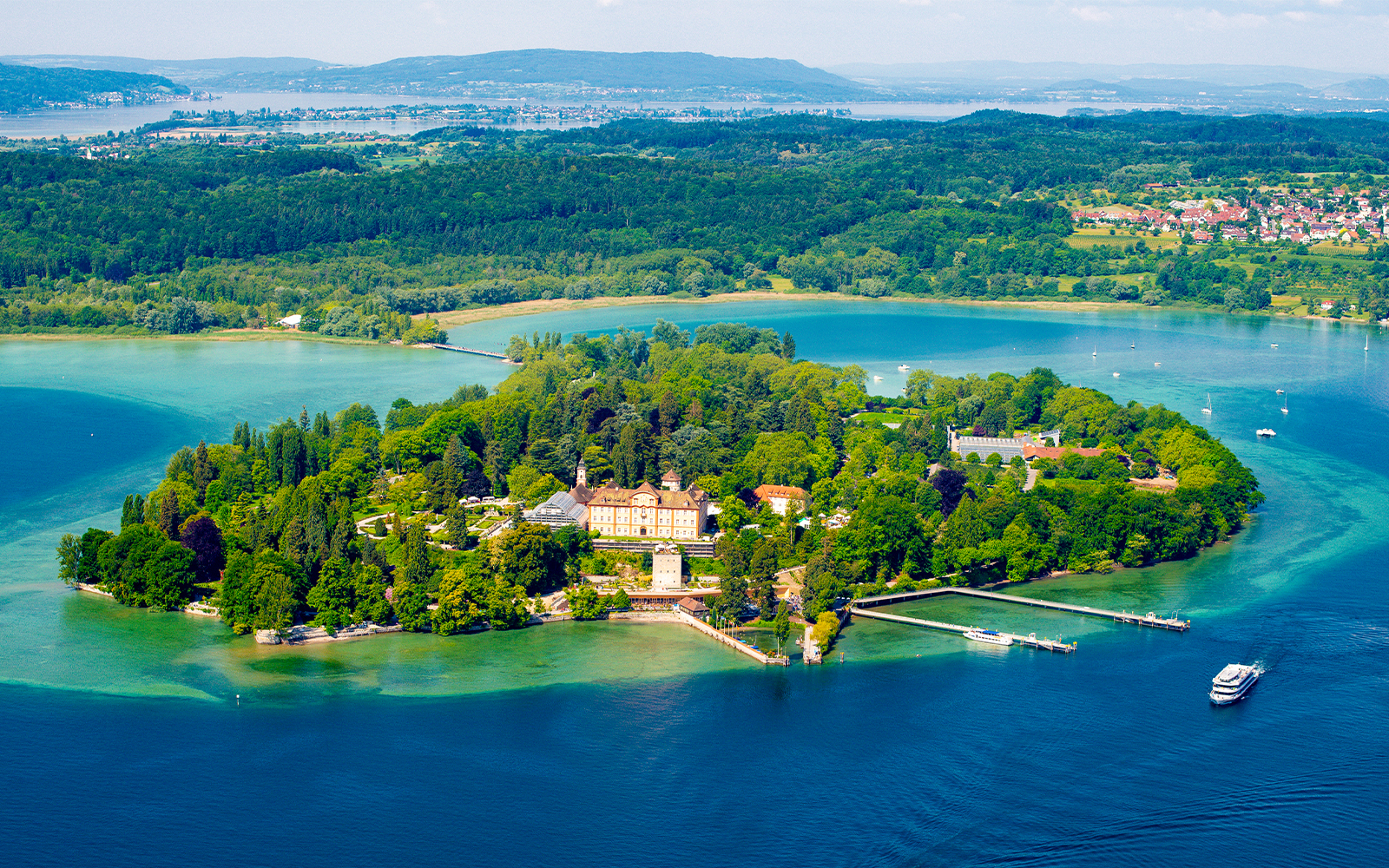 Aerial view of Mainau Flower Island on Lake Constance, surrounded by lush greenery and water.