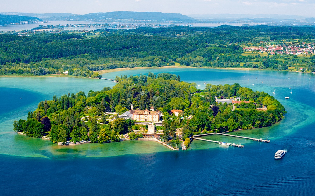 Aerial view of Mainau Flower Island on Lake Constance, surrounded by lush greenery and water.