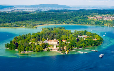Aerial view of Mainau Flower Island on Lake Constance, surrounded by lush greenery and water.