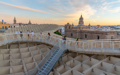 Visitors walking on Setas de Sevilla walkway at sunset, Seville, Spain.