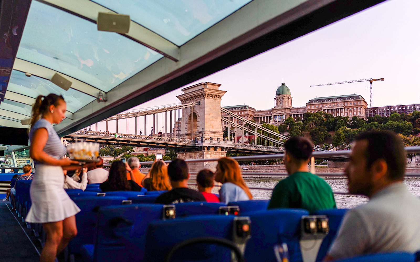 Guests enjoying Budapest Sunset Cruise with view of Chain Bridge and Buda Castle.