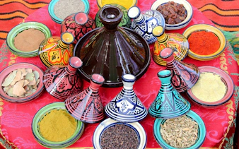 Colorful Moroccan tagines and spices at a market in Agadir.