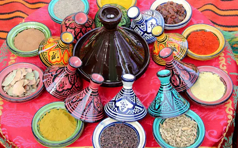 Colorful Moroccan tagines and spices at a market in Agadir.