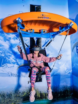 Person experiencing virtual reality paragliding at VR Park Dubai.