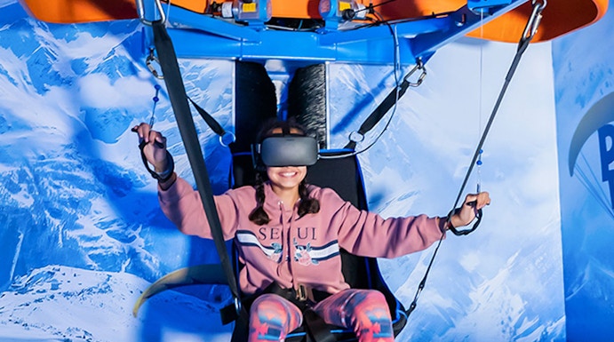 Person experiencing virtual reality paragliding at VR Park Dubai.