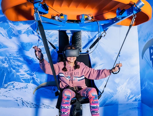 Person experiencing virtual reality paragliding at VR Park Dubai.