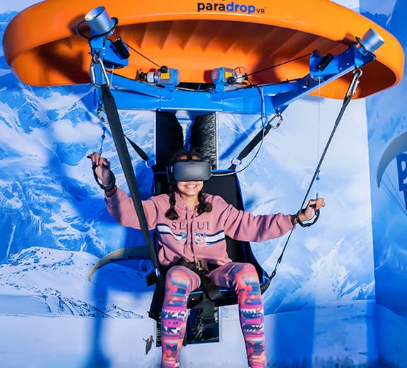 Person experiencing virtual reality paragliding at VR Park Dubai.