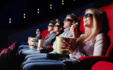Visitors enjoying a 3D movie at Dinopolis cinema with popcorn.