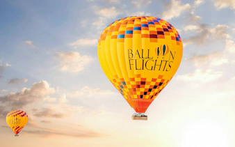 Hot air balloon in the sky during sunrise, part of a tour with hotel transfers, breakfast, camel ride, and quad biking.