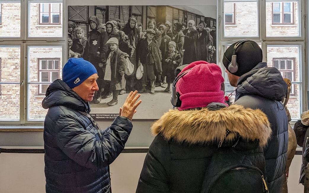 Guide explaining historical photo during Auschwitz Birkenau tour from Wroclaw.