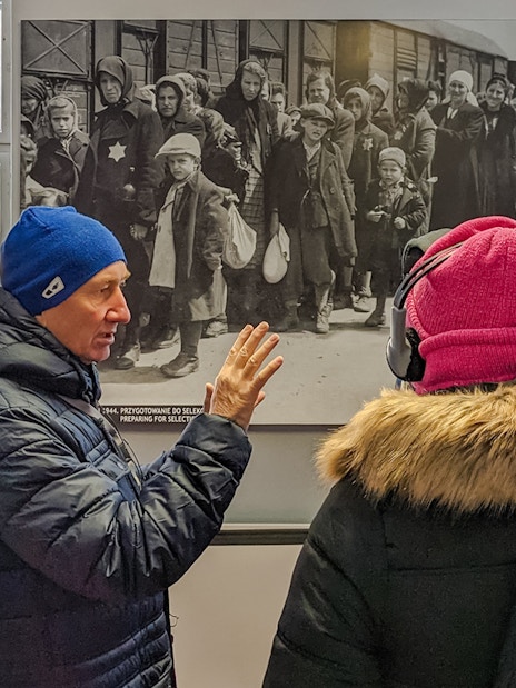 Guide explaining historical photo during Auschwitz Birkenau tour from Wroclaw.