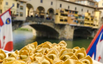 Pasta dish with Ponte Vecchio in the background during a Florence small-group cooking class.