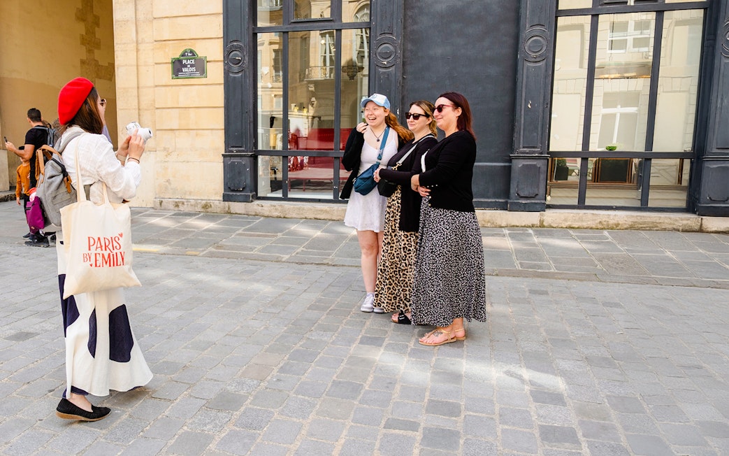 Guide taking Polaroid photos of guests on Emily in Paris Locations Walking Tour.