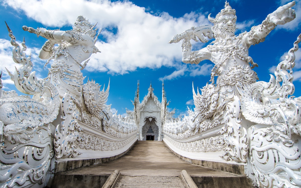 Wat Rong Khun ornate white sculptures and bridge, Chiang Rai, Thailand.