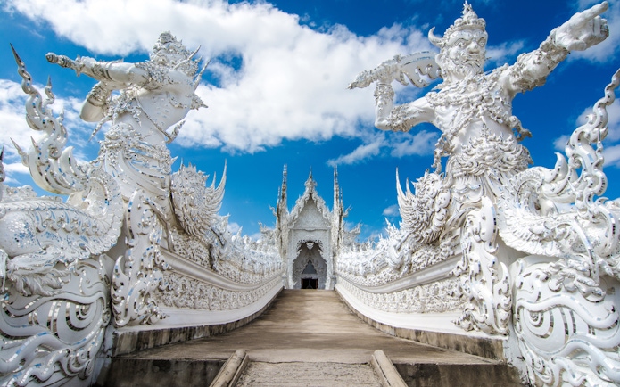 Wat Rong Khun ornate white sculptures and bridge, Chiang Rai, Thailand.