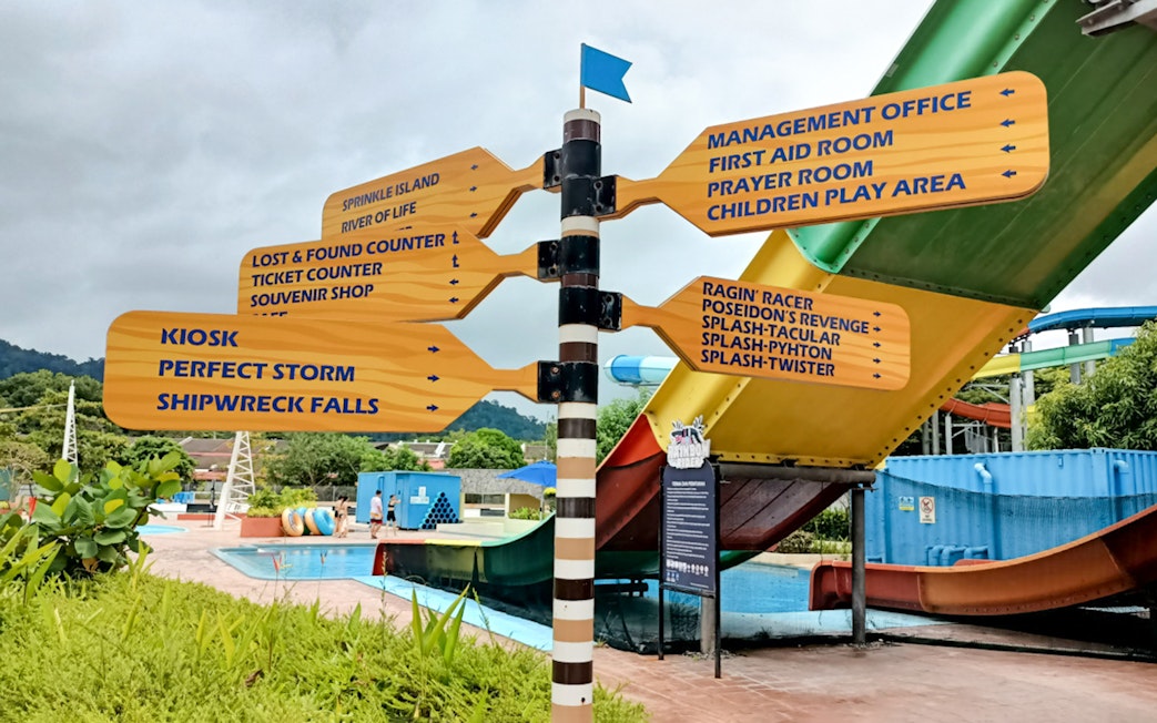 Signpost with directions to attractions at Splash Out Langkawi Water Theme Park, Malaysia.